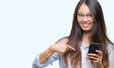 Genç Asyalı kadın manifatura Smartphone sürpriz yüz işaret parmağı kendini izole arka plan üzerinde kullanma