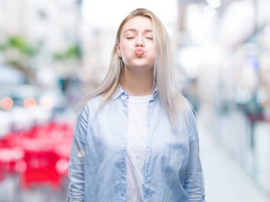 Genç Sarışın kadın komik surat ile yanakları şişirme izole arka plan yüzünden. Ağız ile hava, deli ifade şişirilmiş.