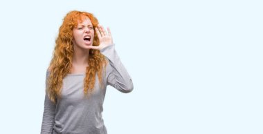 Bağırarak ve ağzı üzerinde el ile yan için çığlık genç Kızıl saçlı kadın. İletişim kavramı.