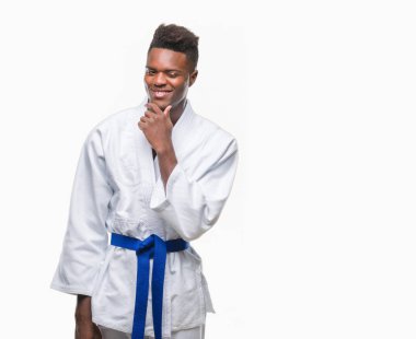 İzole arka plan emin çapraz kollar ve çeneme kaldırdı el ile gülümseme ile kameraya bakarak kimono giyen genç Afro-Amerikan adam. Pozitif düşünce.
