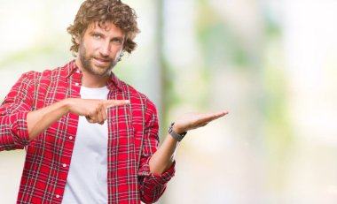 Yakışıklı İspanyol modeli adam üzerinden hayran ve el ile sunulması ve parmak ile işaret ederken kameraya gülümseyen izole arka plan.
