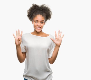 Genç afro Amerikalı kadın gösterilen ve parmakları ile işaret izole arka plan üzerinde numara 9 kendinden emin ve mutlu gülümseyerek süre.