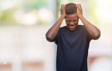 Genç Afro-Amerikan adam çünkü umutsuz ve stresli baş ağrısı acı izole arka plan üzerinde ağrı ve migren. Ellerini kafasına.
