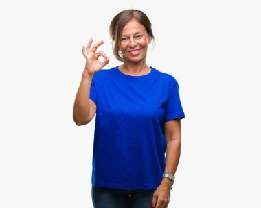 Gülümseyen izole arka plan üzerinde orta yaş İspanyol kadın kıdemli el ve parmaklar ok işaretiyle yapıyor olumlu. Başarılı ifade.