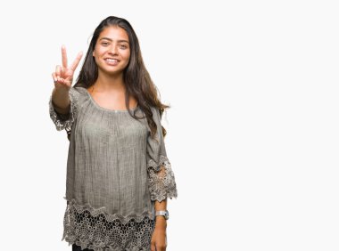 Genç güzel Arap kadın mutlu yüz zafer işareti yaparken kameraya göz kırpıyor ile gülümseyen izole arka plan yüzünden. İki numaralı.