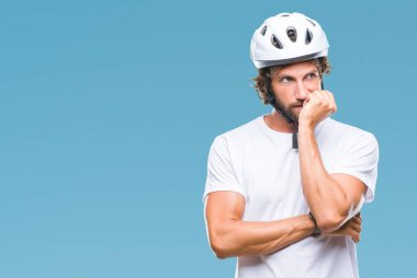 Yakışıklı İspanyol bisikletçi adam stresli ve gergin elle çivi ısırma ağzına bakarak izole arka plan üzerinde güvenlik kask giyiyor. Anksiyete sorunu.