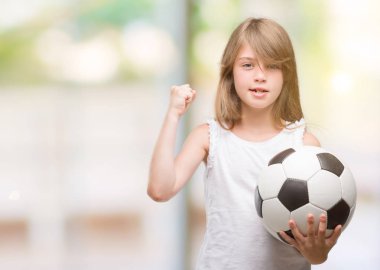 Genç Sarışın yürümeye başlayan çocuk holding futbol topu ile öfke, çılgın ve yükseltilmiş eliyle diye bağıran rahatsız ve hayal kırıklığına uğramış öfke kavramı bağırarak
