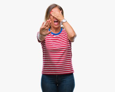 Orta yaş üst düzey İspanyol kadın izole elleriyle gözlerini kapsayan arka plan ve stop jest ile acı ve korku ifadesi. Utandım ve negatif kavramı.