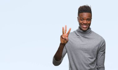 Gösterilen ve parmakları ile işaret izole arka plan üzerinde genç Afro-Amerikan adam kendinden emin ve mutlu gülümseyerek iken üçüncü.
