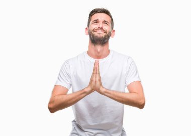 Yakışıklı delikanlı yalvarıyor ve umut ifade yüzünde çok duygusal ve endişe ile birlikte elleriyle dua izole arka plan üzerinde. Bağışlanmak. Din kavramı.