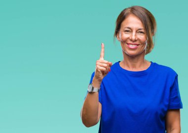 Orta yaş ve parmak gülümseyen süre bir numara ile kendinden emin ve mutlu yukarıyı gösteren izole arka plan üzerine İspanyol kadın kıdemli.