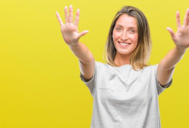 Genç güzel kadın gösterilen ve parmakları ile işaret izole arka plan yüzünden kendinden emin ve mutlu gülümseyerek süre on numara.