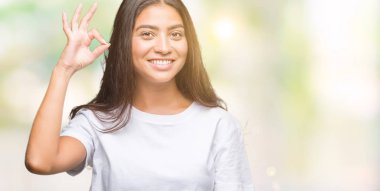 Gülümseyen izole arka plan üzerinde genç güzel Arap kadın el ve parmaklar ok işaretiyle yapıyor olumlu. Başarılı ifade.