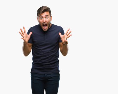 Yakışıklı delikanlı deli kutluyor ve silah ile başarı için heyecanlı çığlık kaldırdı ve açık gözleri hayret izole arka plan üzerinde. Kazanan kavramı