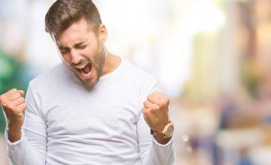 Soyutlanmış, mutlu ve heyecanlı genç bir adam kollarını kaldırmış, gülümseyen ve başarı için çığlık atan kazanan bir jest yapıyor. Kutlama konsepti.