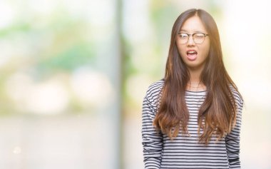 Seksi bir ifadeyle, neşeli ve mutlu yüzünü kameraya bakarak göz kırpıyor izole arka plan üzerinde gözlük takan Genç Asyalı kadın.