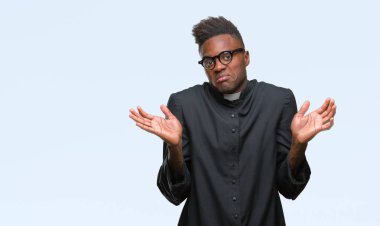 Genç Afro-Amerikan rahip adam izole arka plan clueless ve şaşkın bir ifadeyle kollar ve eller kaldırdı. Şüphe kavramı.