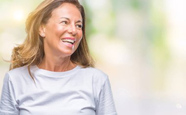 İzole arka plan uzak tarafına gülümseme ile yüzünde, doğal ifade seyir üzerinde orta yaş İspanyol kadın kıdemli. Kendine güvenen gülüyor.