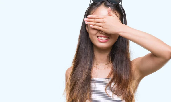 若いアジアの女性は微笑し 笑う顔驚きの目を覆っている手で孤立の背景の上にサングラスをかけています 視覚障害者の概念 — ストック写真