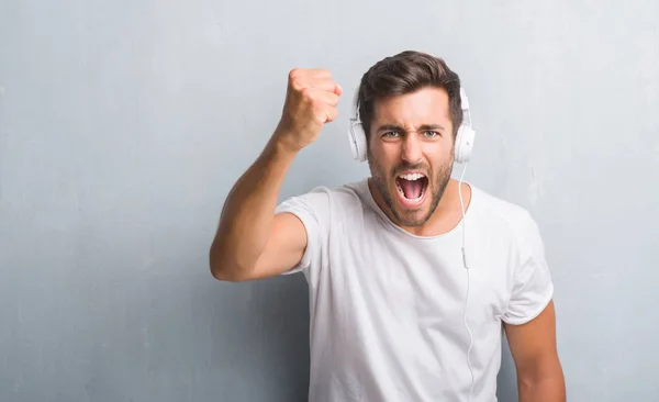 Guapo Joven Sobre Gris Pared Grunge Usando Auriculares Escuchando Música —  Fotos de Stock