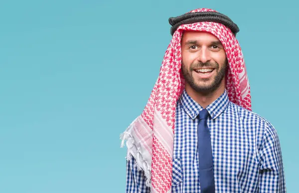 年轻英俊的阿拉伯商人穿着 Keffiyeh 在与世隔绝的背景下 脸上带着愉快和凉爽的笑容 幸运的人 — 图库照片