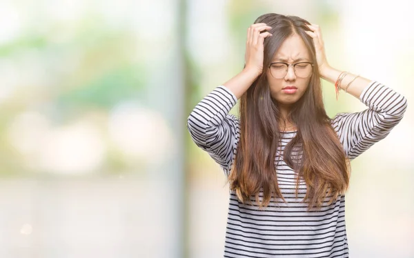 若いアジア女性ため必死と強調した頭痛に苦しんで孤立の背景に眼鏡をかけてのの痛みと片頭痛 頭に手 — ストック写真