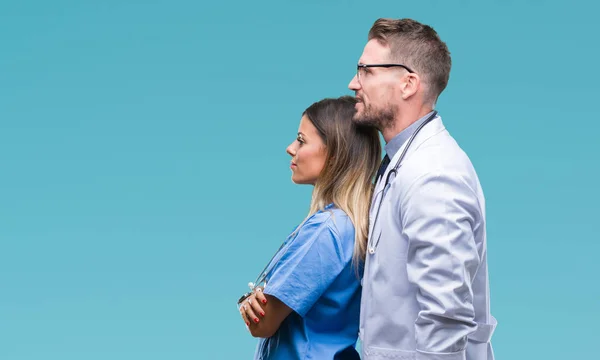 Young couple of doctor and surgeon over isolated background looking to side, relax profile pose with natural face with confident smile.