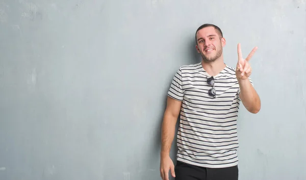 Joven Hombre Caucásico Sobre Pared Gris Grunge Sonriendo Mirando Cámara —  Fotos de Stock