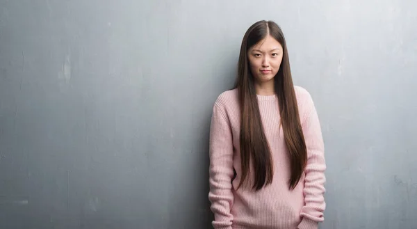 Junge Chinesin Über Graue Wand Skeptisch Und Nervös Und Runzelt — Stockfoto