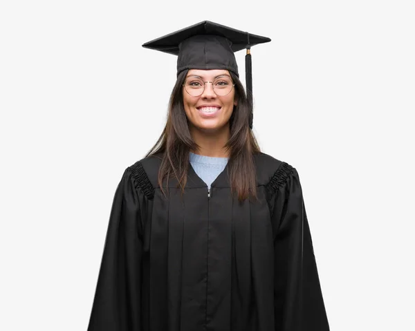 若いヒスパニック系女性の顔に卒業キャップと幸せとクールな笑顔で制服を着ています 幸運な人 — ストック写真