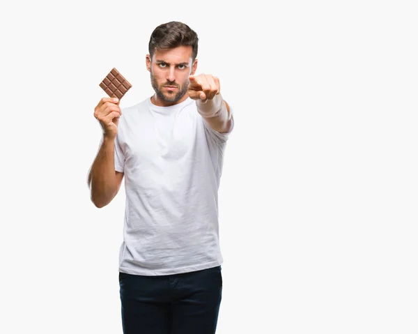 Homem Bonito Jovem Comendo Barra Chocolate Sobre Fundo Isolado Apontando — Fotografia de Stock