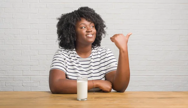 Joven Mujer Afroamericana Sentada Mesa Bebiendo Vaso Leche Señalando Mostrando — Foto de Stock