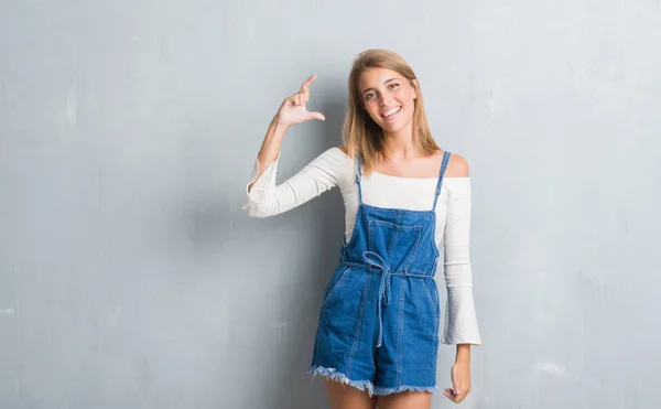 Mulher Bonita Jovem Sobre Parede Cinza Grunge Sorrindo Gestos Confiantes — Fotografia de Stock