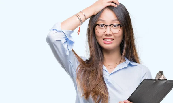 Jovem Mulher Negócios Asiática Segurando Prancheta Sobre Fundo Isolado Estressado — Fotografia de Stock