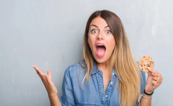 Young Adult Woman Grey Grunge Wall Eating Chocolate Chip Cooky — Stock Photo, Image