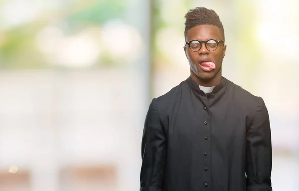年轻的非洲裔美国教士人在隔绝的背景下黏附舌头愉快以滑稽的表示 情感概念 — 图库照片