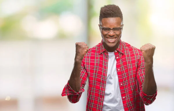 Νεαρός Αφρικανική Αμερικανική Άνθρωπος Πάνω Από Απομονωμένες Φόντο Γιορτάζει Έκπληκτος — Φωτογραφία Αρχείου