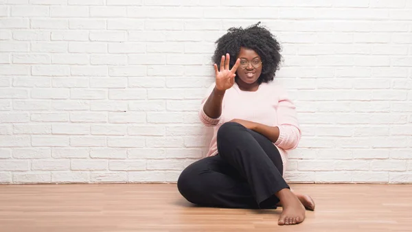 Jovem Afro Americana Sentada Chão Casa Mostrando Apontando Para Cima — Fotografia de Stock