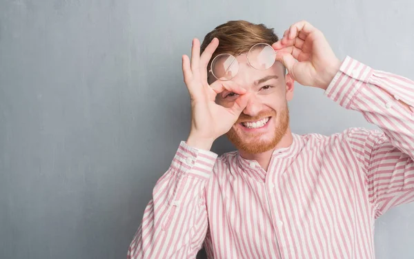 Unga Rödhårig Man Över Grå Grunge Vägg Med Glada Ansikte — Stockfoto