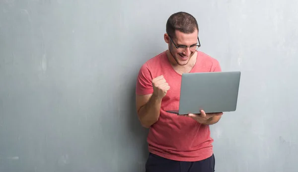 Joven Caucásico Hombre Sobre Gris Grunge Pared Usando Computadora Portátil — Foto de Stock