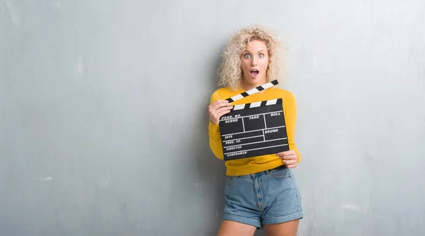 Sarışın Genç Kadın Grunge Üzerinde Gri Duvar Calpboard Film Korkmuş — Stok fotoğraf