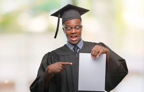 若者は 非常に幸せな手と指で指している孤立した背景に白紙の学位を保持するアフリカ系アメリカ人を卒業 — ストック写真