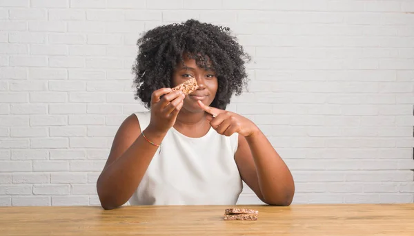 Jovem Afro Americana Sentada Mesa Comendo Barra Cereais Muito Feliz — Fotografia de Stock