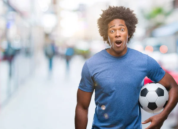 Hombre Afroamericano Sosteniendo Pelota Fútbol Sobre Fondo Aislado Asustado Shock —  Fotos de Stock