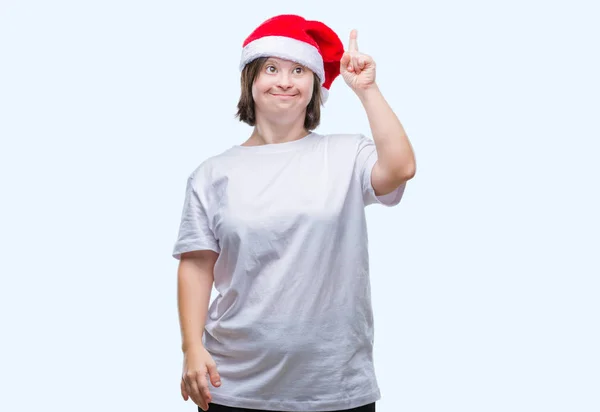 成功したアイデアを分離背景人差し指上クリスマス帽子をかぶっているダウン症の若い大人の女性 終了したと満足しています ナンバーワン — ストック写真