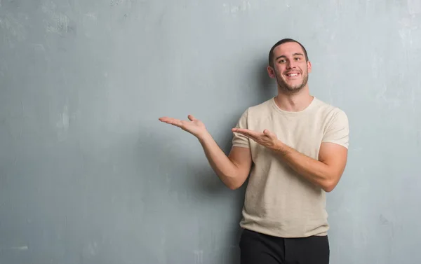 Giovane Uomo Caucasico Sulla Parete Grigia Grunge Stupito Sorridente Alla — Foto Stock