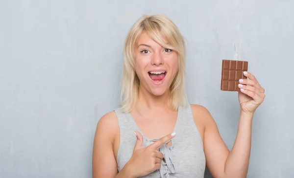 Caucasian Adult Woman Grey Grunge Wall Eating Chocolate Bar Very — Stock Photo, Image