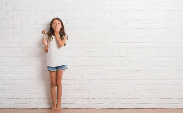 Niño Hispano Joven Sobre Pared Ladrillo Blanco Comiendo Caramelos Piruleta —  Fotos de Stock