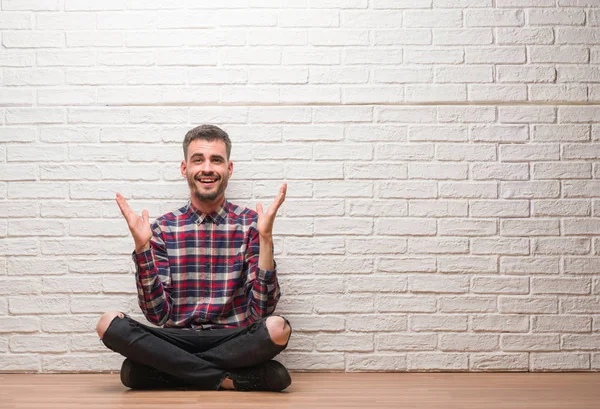 Mladý Dospělý Muž Sedí Nad Bílá Cihlová Zeď Velmi Šťastný — Stock fotografie