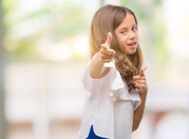 Esmer İspanyol kız kameraya mutlu ve komik suratla parmakları işaret. İyi enerji ve vibes.